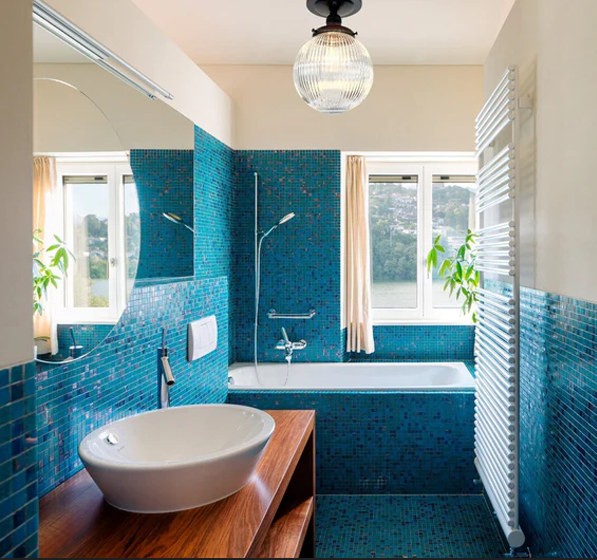 Coastal bathroom with teal tile and glass globe lighting