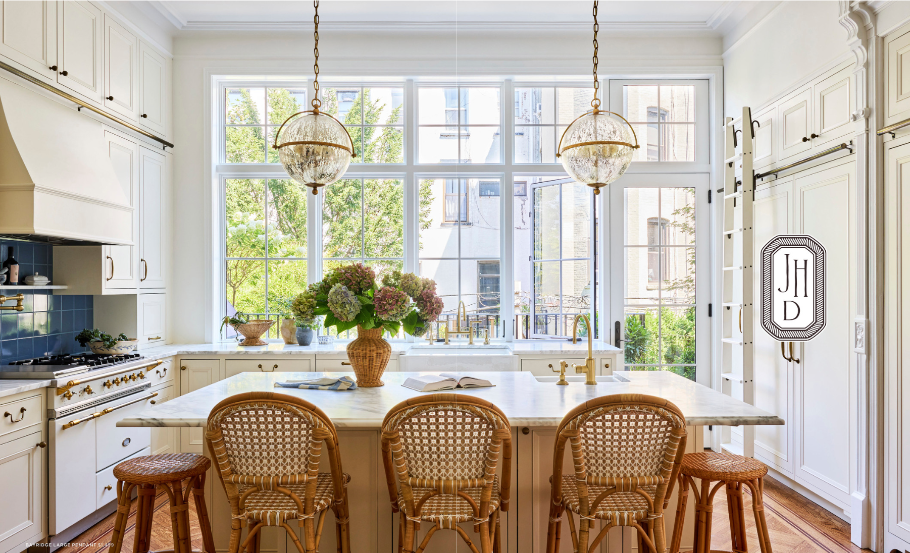Bright kitchen with island pendants, brass hardware, and layered natural and artificial light