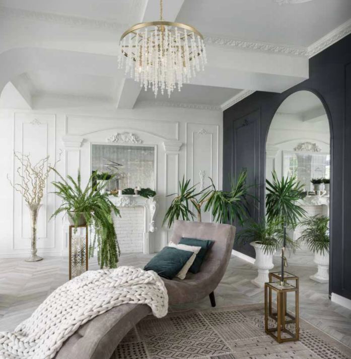 Living room with crystal chandelier ambient light, plants, and layered warm decorative lighting