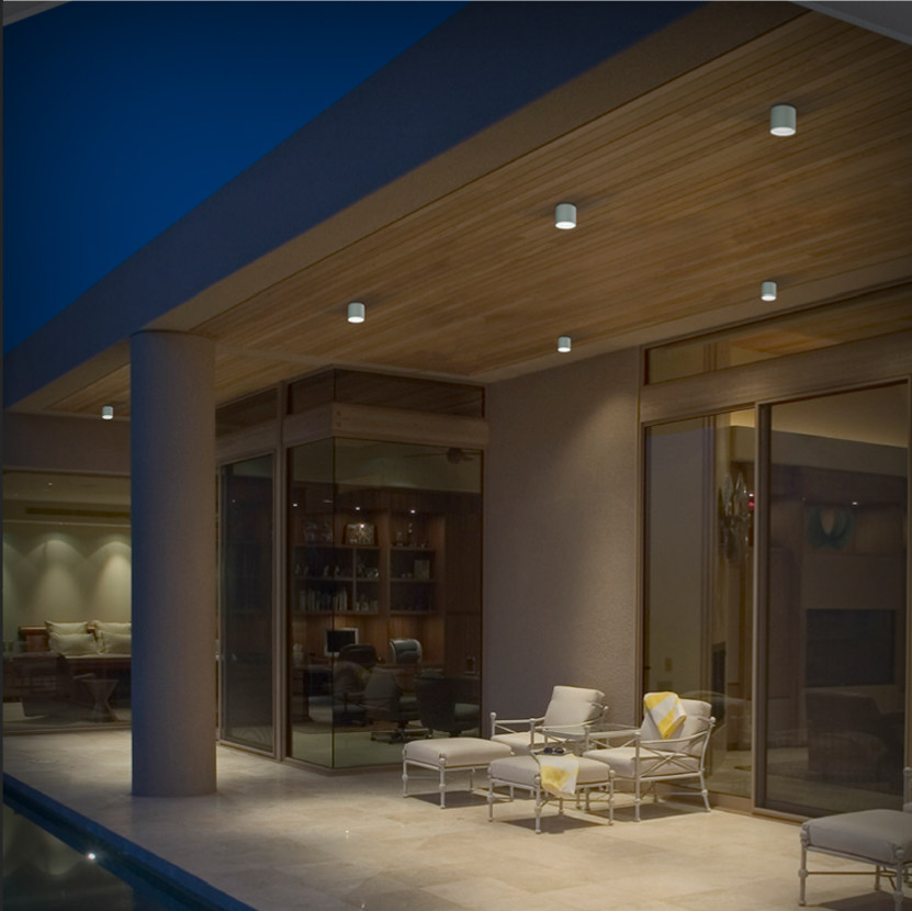 Covered patio at night with downlights, interior glow, and poolside ambient lighting