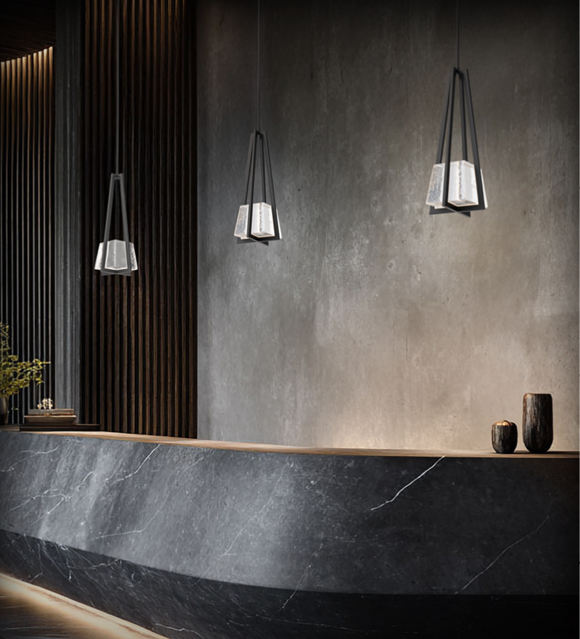 Three modern pendant lights in a staggered row over a kitchen island counter